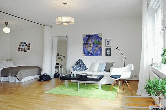 Interior do apartamento com separação de espaço com uma cama de cortina branca do teto ao chão
