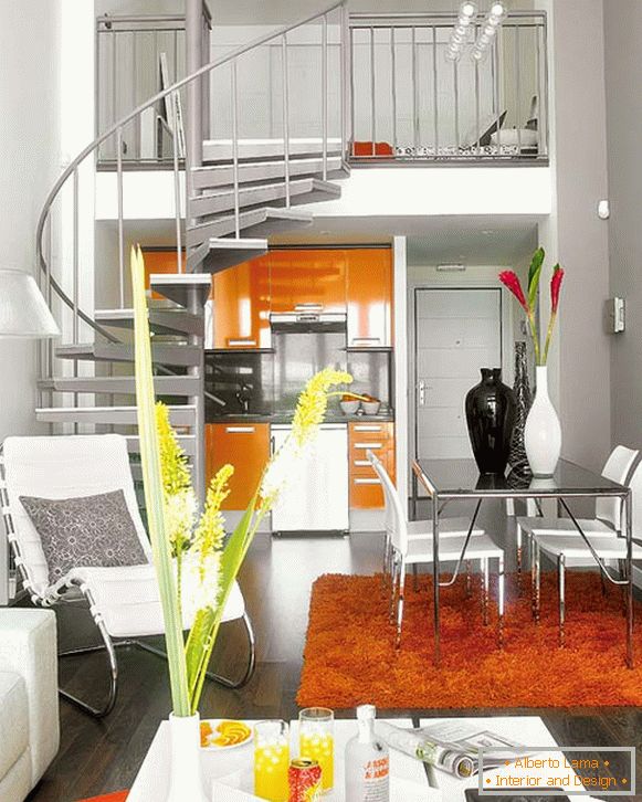Interior do apartamento com uma escada em espiral para o segundo nível acima da cozinha