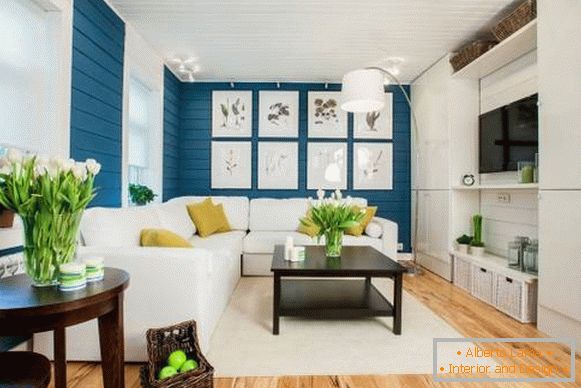 Sofá branco no interior com papel de parede azul e piso de madeira