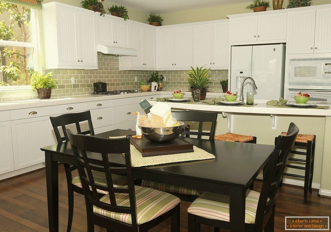 Mesa preta com cadeiras e móveis brancos na cozinha