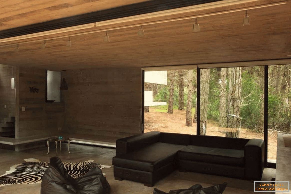 Sala de estar com acabamento em madeira em uma casa de madeira com uma janela panorâmica
