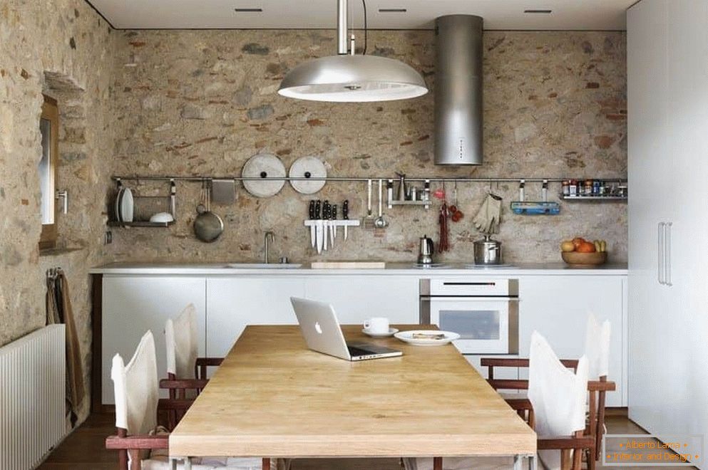 Cozinha com paredes de concreto e um grande armário com uma área de jantar