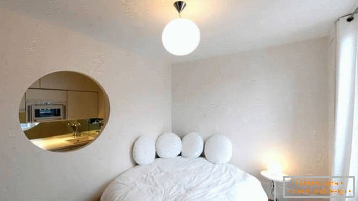 O vazio na parede da forma oval faz de um pequeno apartamento um estúdio de luxo.