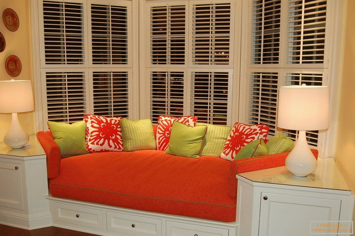 Sofá vermelho com almofadas coloridas