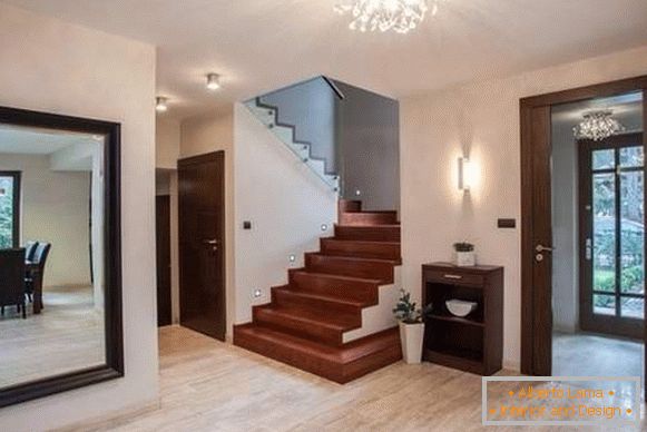 Design do corredor em uma casa particular com grandes espelhos e escadas