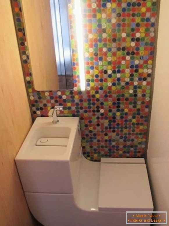 Um pequeno banheiro com um vaso sanitário moderno e mosaico brilhante