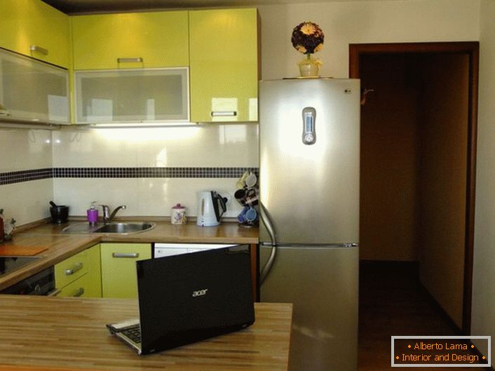 Cozinha elegante área de 12 metros quadrados de cor verde oliva. O espaço da cozinha é organizado de forma prática e funcional.