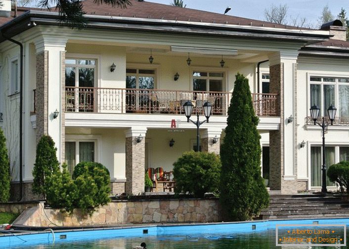 O quintal da casa no estilo mediterrâneo é decorado com um lago artificial. Design perfeito de áreas suburbanas. 