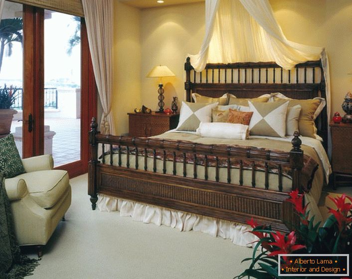 Cama luxuosa no quarto no estilo do ecletismo. Baldachin acima da cama, cortinas de luz nas portas que levam para a varanda tornam o quarto aconchegante e romântico. 
