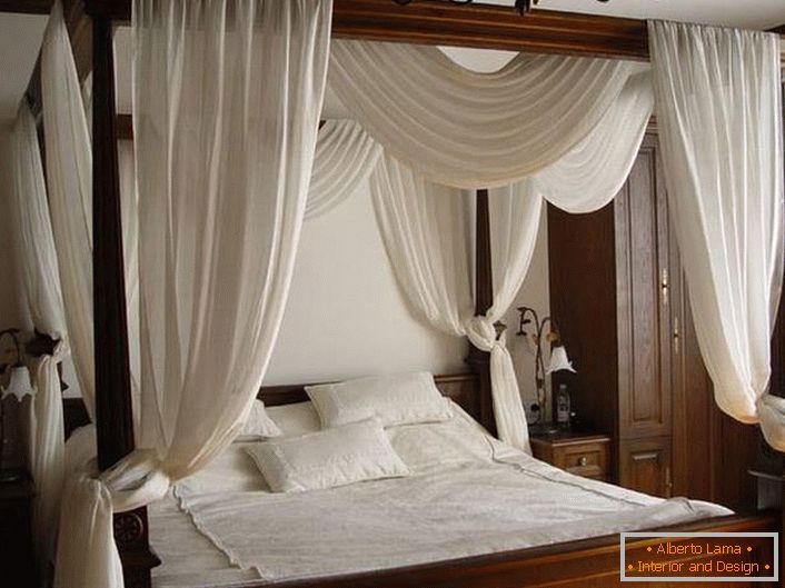 Um dossel branco sobre uma cama simples e lacônica feita de madeira.