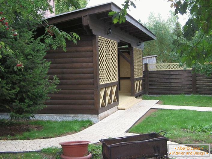 Um gazebo escuro feito de madeira no estilo de um chalé é uma escolha popular para os proprietários de imóveis suburbanos modernos.
