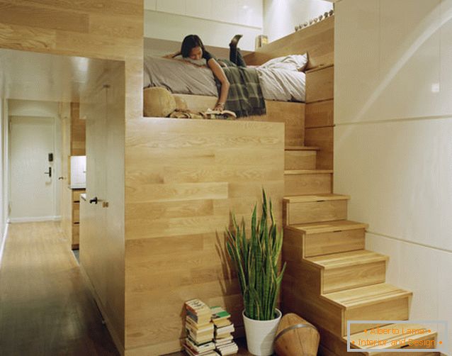 Cama de dois andares em um apartamento retangular com uma janela
