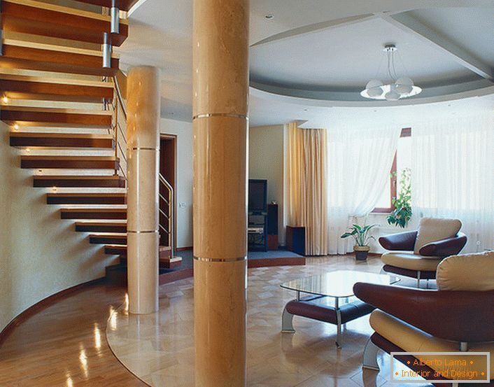 Uma espaçosa sala de estar brilhante sob uma escada em um apartamento de dois níveis. 