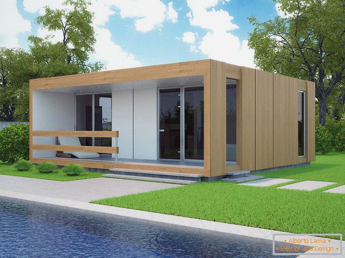 Uma pequena casa modular com piscina no quintal. O design elegante de uma casa que está sendo construída rapidamente parece organicamente no contexto de um curto gramado cortado.