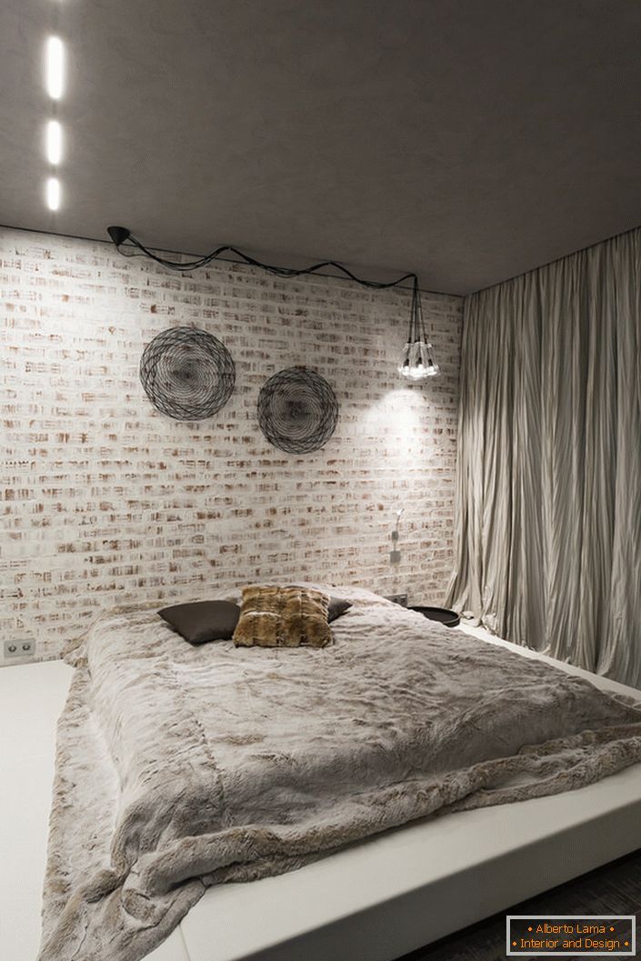 O quarto no estilo loft deve conter no seu interior um mínimo de mobília. Uma boa escolha para este conceito de estilo é uma grande cama macia em um pódio baixo.