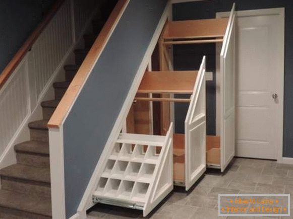 Escadas em uma casa particular - foto com um armário sob as etapas