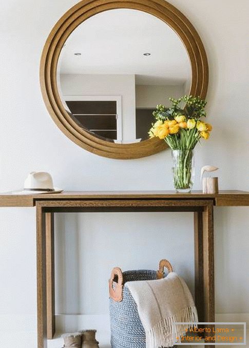 Espelho redondo no corredor com acabamento em madeira