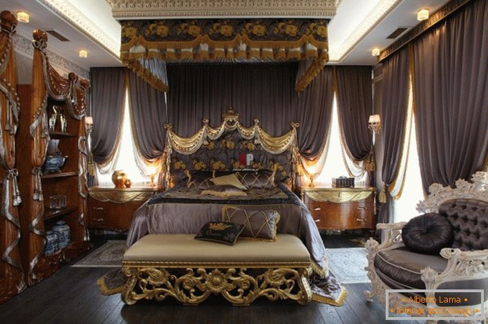 Quarto de luxo em estilo barroco. No centro da composição é uma cama enorme com uma cabeceira alta decorada.