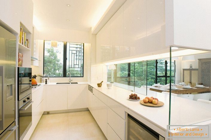 A cozinha é separada da sala de estar por uma parede de vidro decorativo. Uma solução interessante para o interior no estilo de oi assim.