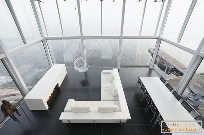 Design lacônico da sala de estar em estilo minimalista. Um móvel interessante é uma cadeira suspensa por um teto alto.
