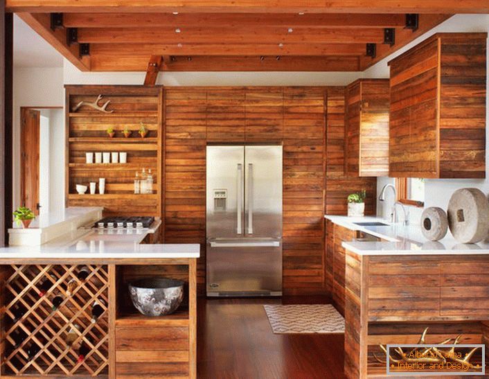 A moderna cozinha em estilo de chalé é notável por sua decoração lacônica e discreta. O conjunto de madeira sem mobília extra parece elegante e eficaz.