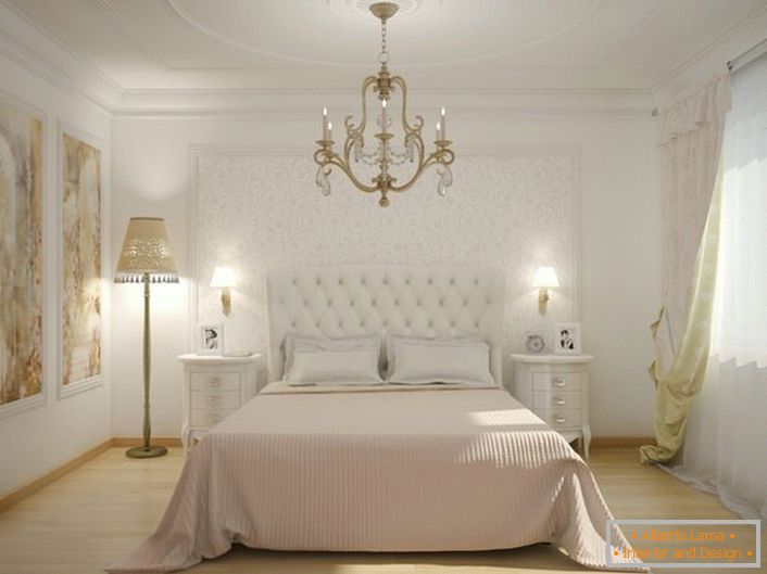No centro do interior do quarto há uma cama com uma cabeceira estofada de pano. O estofamento macio e acolchoado torna a atmosfera nobre e elegante.