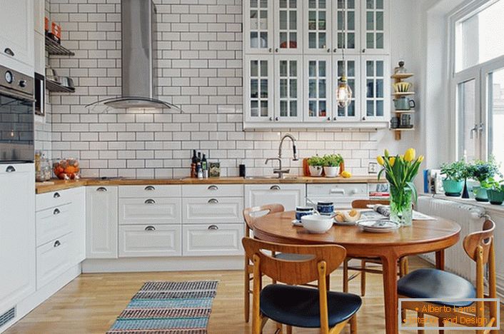 O interior da cozinha é feito em estilo escandinavo, que é expresso em um design branco e calmo. 