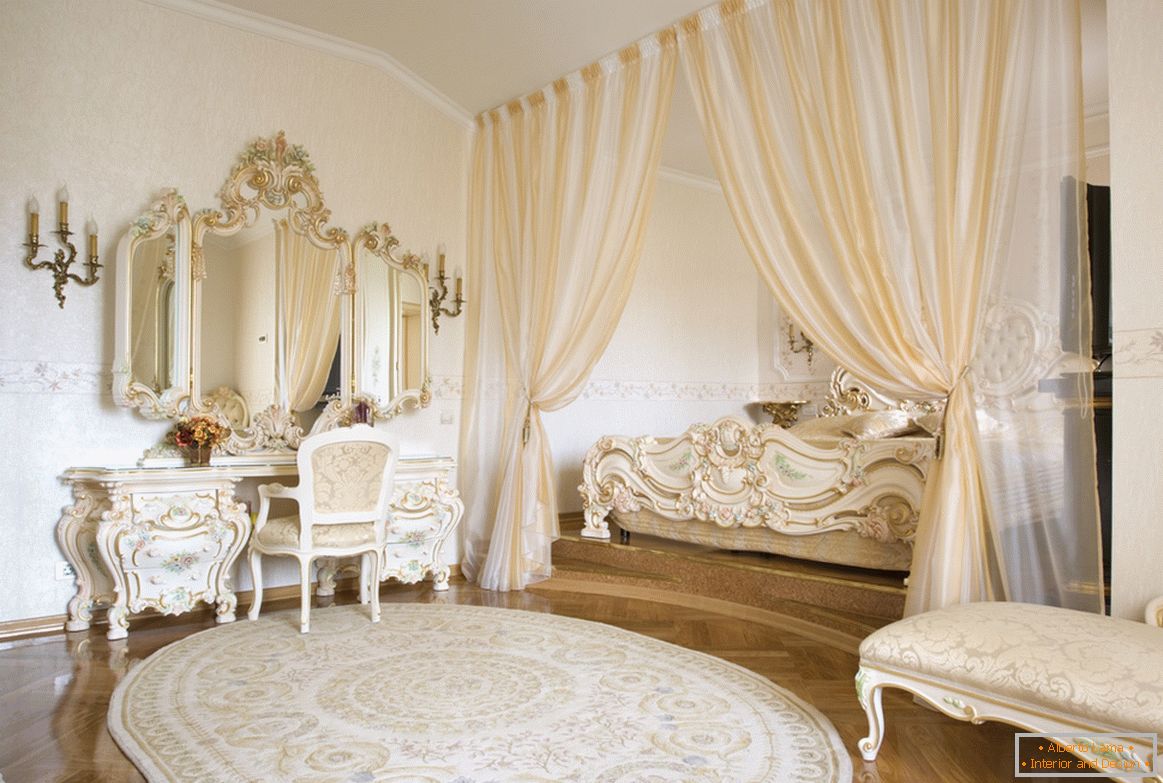 Espelhos emoldurados e elementos decorativos de móveis são feitos em um estilo com o uso de ouro. Para economizar espaço, a cama está escondida em um nicho emoldurado por cortinas.