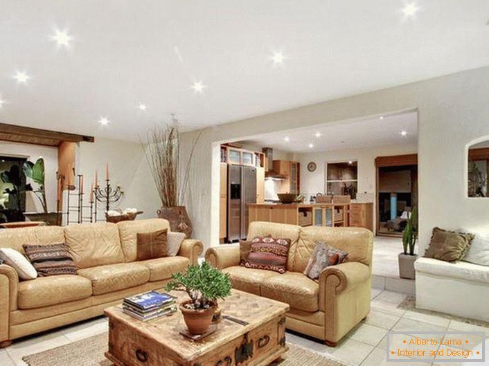 Luxuoso e elegante interior da sala de estar em estilo mediterrâneo. Móveis bege macios e claros, iluminação adequada, chão de azulejos - testemunho o estilo mediterrânico.