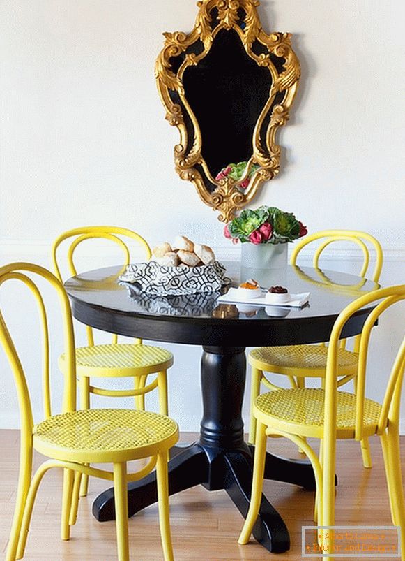 Cadeiras amarelas brilhantes e uma mesa de jantar preta
