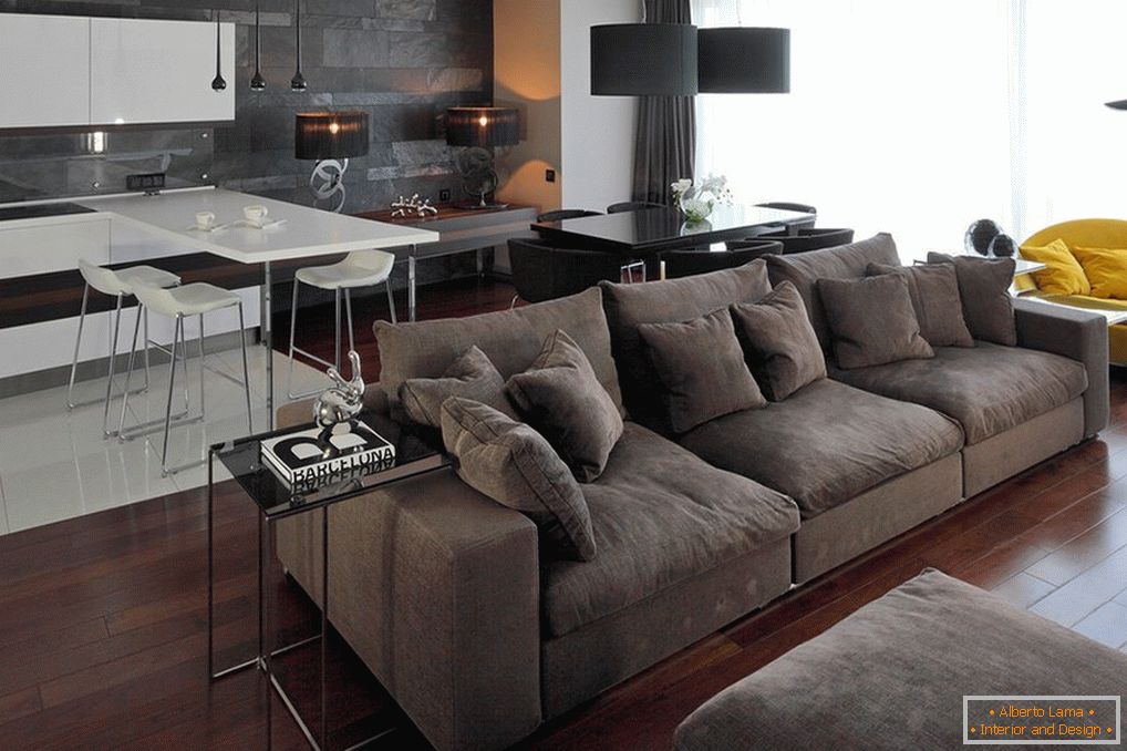 Um pequeno sofá cinza no interior do apartamento