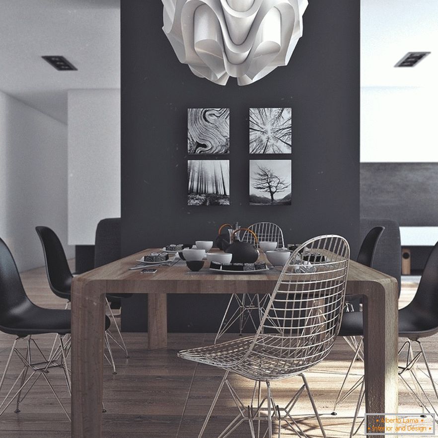 Uma mesa de jantar de madeira, cadeiras pretas e pinturas originais em uma parede preta