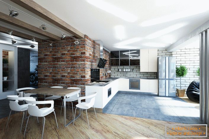A cozinha, combinada com a sala de estar, é decorada em estilo loft. Um interior lacônico e discreto fala de um senso do estilo do designer. 