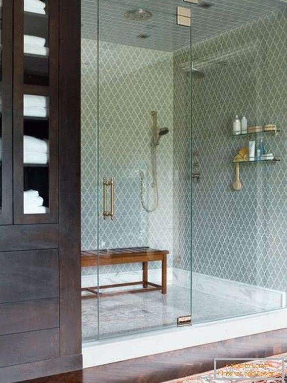 Uma porta de vidro bonita para um chuveiro em um nicho com uma cerca