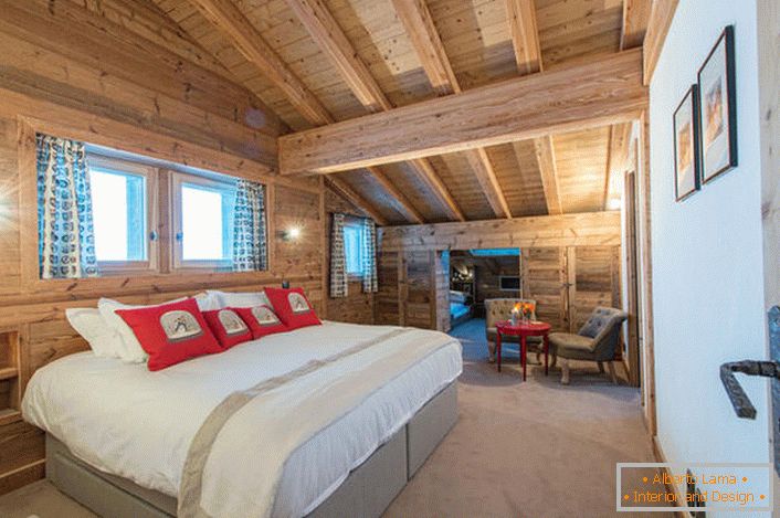 Um espaçoso quarto no segundo andar de uma casa de campo a partir de uma casa de madeira. В соответствии со стилем кантри искусственный свет в комнате приглушен. 