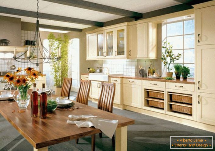 Cozinha no estilo do país na casa grande de uma família italiana bem-fazer. Para o estilo country, um conjunto de madeira de cozinha em tons de bege claro é bem escolhido.