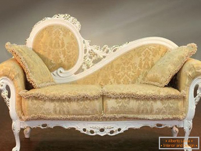 A parte de trás do sofá esculpida e o estofamento bege macio com um ornamento quase imperceptível nas melhores tradições do barroco.