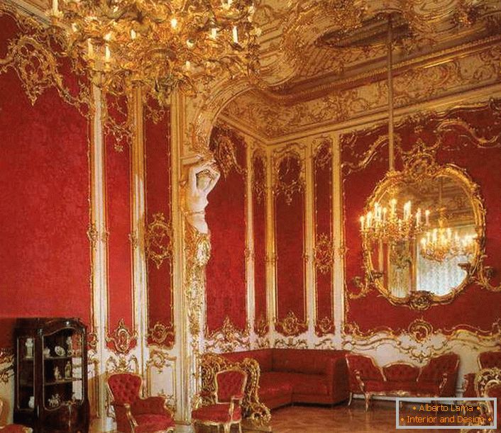 A sala de estar da casa está devidamente decorada com móveis vermelhos. O vermelho nobre é perfeitamente combinado com elementos de acabamento dourados.