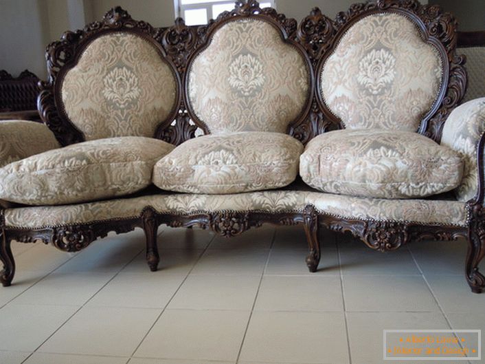 Borda ornamentada das costas, pernas esculpidas, estofamento têxtil - a escolha perfeita para uma sala de estar de estilo barroco.