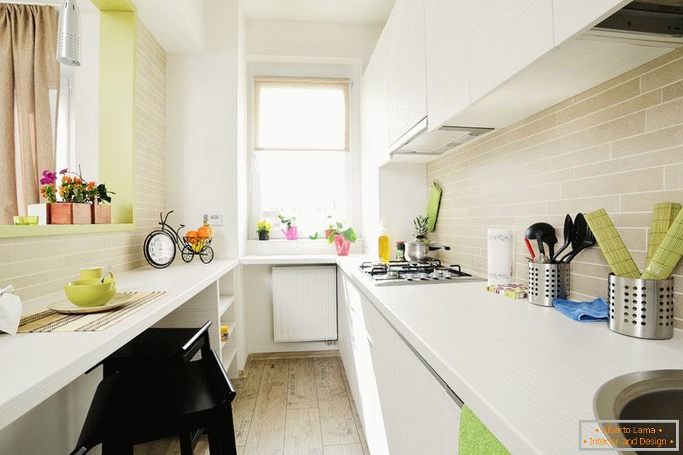 Cozinha branca longa com detalhes em verde claro