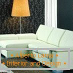 Lâmpada de assoalho laranja ao lado de um sofá branco