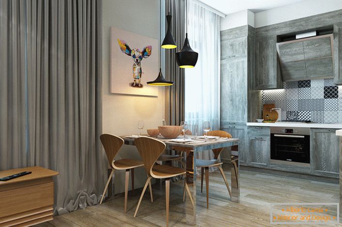 O conjunto de cozinha é cinza pálido combinado com cortinas pesadas feitas de tecidos naturais.