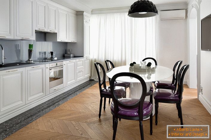 Cozinha interior branca com toques de cinza escuro em estilo eclético. Cadeiras interessantes com costas transparentes e estofos roxos e macios.