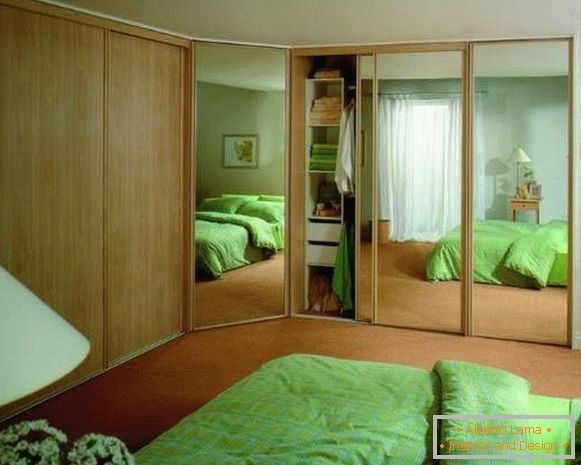 Armário embutido de canto no quarto com portas espelhadas