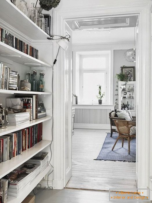 Um pequeno corredor com uma biblioteca em estilo escandinavo