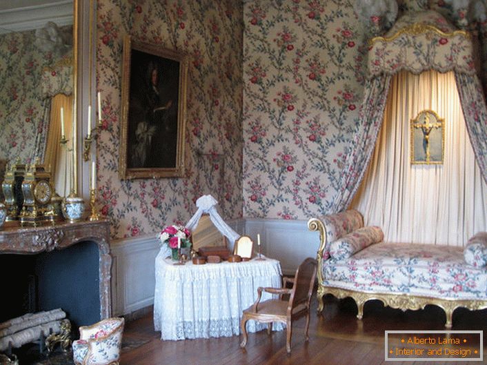 A decoração colorida das paredes está em harmonia com o estofamento do sofá e dossel sobre ele. Um salão barroco com uma grande lareira é uma ótima idéia para uma casa de campo.