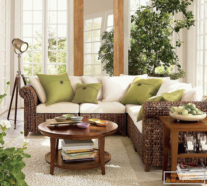 Grandes janelas com molduras de madeira deixam entrar na sala de estar em estilo ecológico uma quantidade suficiente de luz solar, que deve prevalecer no quarto.