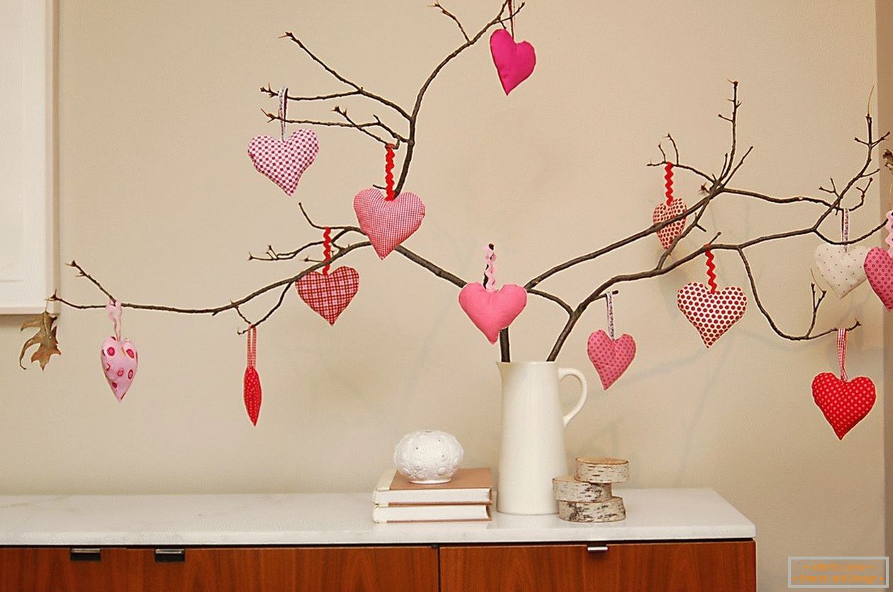 Ramos de árvores decoradas com corações feitos de feltro
