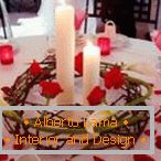 Decoração de uma mesa com velas e pétalas de rosa