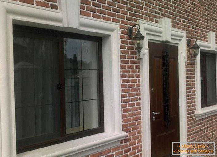A alvenaria de tijolo é organicamente combinada com uma moldagem de fachada, janela de enquadramento e aberturas de porta.